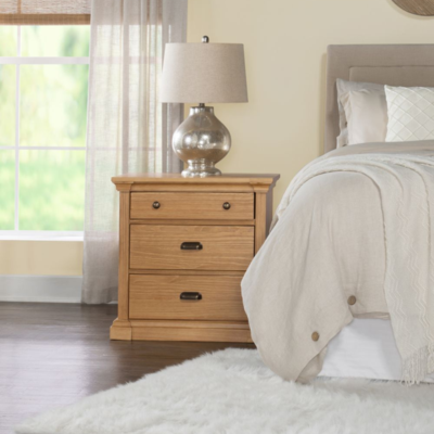 A cozy bedroom with a comfortable bed, a nightstand, and a lamp
