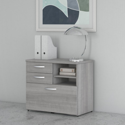 A gray cabinet with drawers and a lamp on top