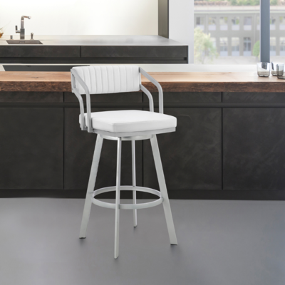 A modern white bar stool with backrest, positioned next to a kitchen island with a dark countertop