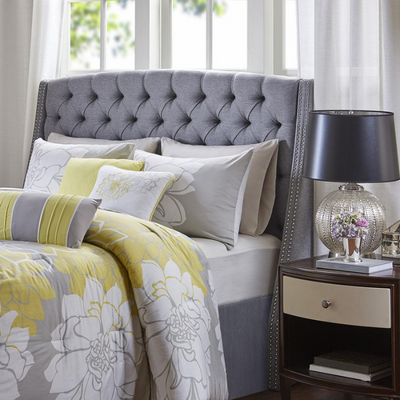 a bed with a headboard and a lamp