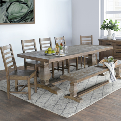 a dining table with a bench and a bowl of fruit on it